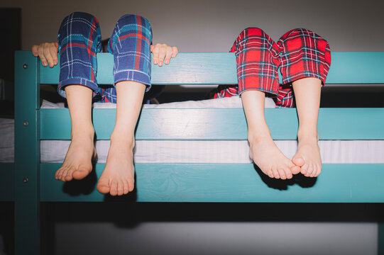 Two brothers in retro pajamas playing and fooling around on bunk bed