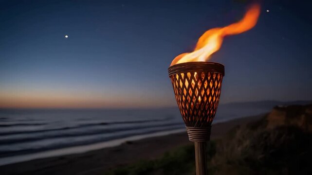 Tropical tiki torch casts a warm light on a peaceful beach at dusk.