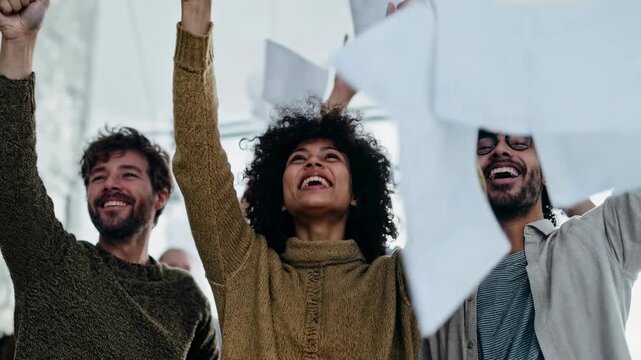 Joyful team throws papers into the air celebrating a big win; contagious workplace optimism and modern office energy perfect for corporate success stories, HR culture reels and teamwork motivation cam