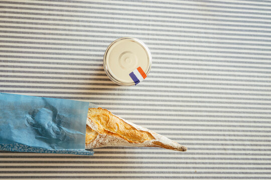 French baguette and marmalade on striped table with copy space
