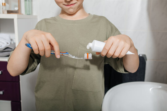 Child preparing to brush teeth with toothpaste in bathroom