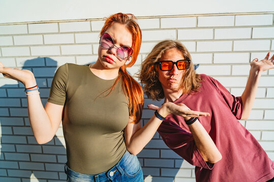 Teenagers with funny glasses pose playfully showing confidence outdoors
