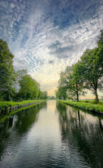 A calming view of a meandering river reflecting the sky, bordered by lush trees in a serene natural setting