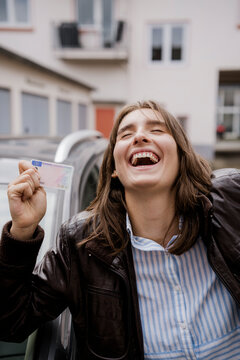 Happy woman celebrating driver license success outdoors