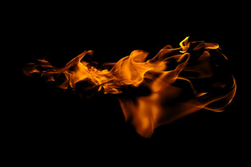Blazing fire and glowing flames on a dark background perfect for creative design and visual effects.
