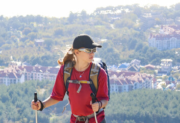 young girl with a backpack is hiking alone in nature