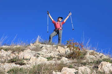 young girl with a backpack is hiking alone in nature