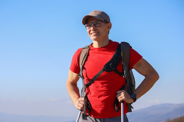 young manl with a backpack is hiking alone in nature