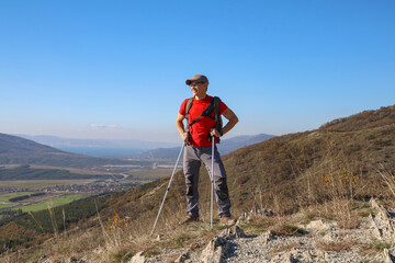 young manl with a backpack is hiking alone in nature