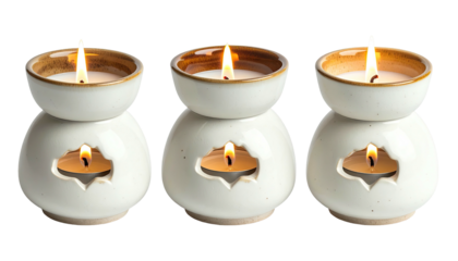 Three ceramic wax melters with lit tea lights glowing softly