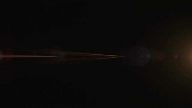 A horizontal golden light streak across a dark background with lens flare effect