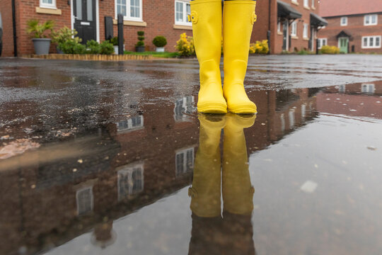 Close-up of woman standing in water puddle during rainy season