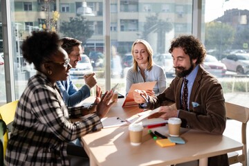 Diverse business team collaborating during meeting in coffee shop