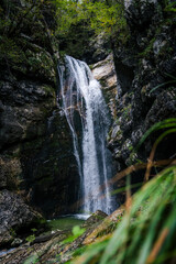 Mostnica Waterfall with Grass in Foreground on an Overcast Day