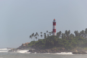 Striking Red and White Lighthouse on a Lush, Palm-Covered Island Headland