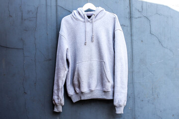 Stylish White Hoodie Hanging Against Warm Wooden Backdrop