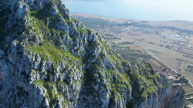 Aerial drone footage of Monte Monaco, San Vito Lo Capo, Sicily: 360&deg; panoramic view of sea and mountains under golden Mediterranean light. Perfect for travel, nature, and adventure projects.