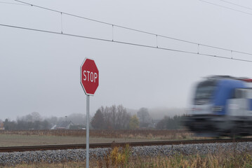  SIGN STOP - A red sign against the background of a speeding intercity express train locomotive