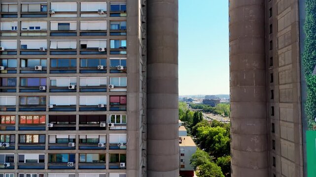 Aerial drone close-up of Genex Tower in Belgrade, Serbia iconic brutalist skyscraper of Yugoslav modernism, showing the narrow passage between twin concrete towers.
