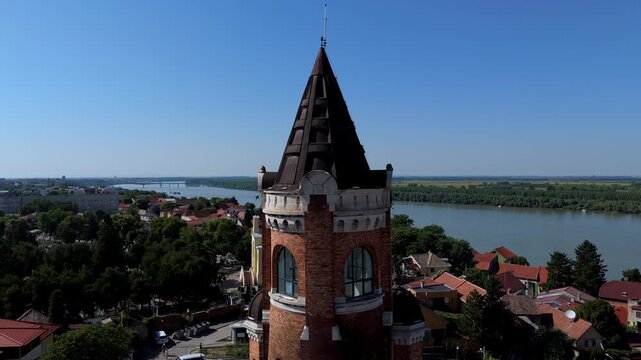 Aerial close up of Gardos Tower in Zemun, Belgrade, Serbia historic brick landmark overlooking the Danube River, surrounded by red rooftops and old town architecture.