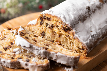Traditional Christmas Stollen with Raisins and Powdered Sugar on wooden table