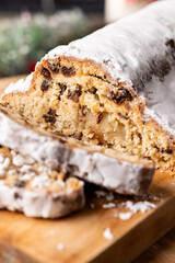 Traditional Christmas Stollen with Raisins and Powdered Sugar on wooden table