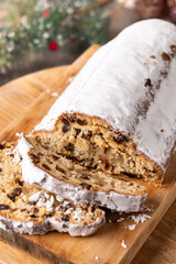 Traditional Christmas Stollen with Raisins and Powdered Sugar on wooden table