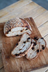 Artisan sourdough bread loaf sliced on parchment paper Wooden table background