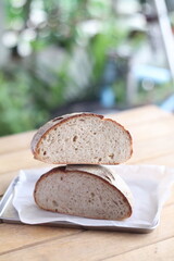  Artisan sourdough bread loaf sliced on parchment paper Wooden table background