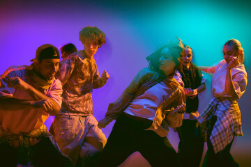 Group of street dancers moving in colorful motion blur. Concept of urban lifestyle, teamwork, and youth culture visuals for creative campaigns, entertainment, and advertising design.