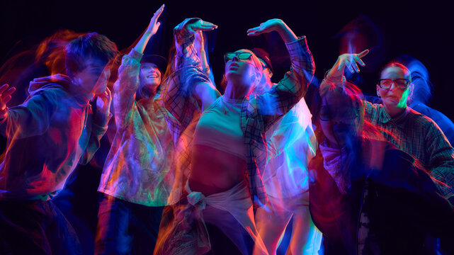 Hip hop group performing in neon blur motion on stage. Concept of performing arts, creative branding, youth advertising, and fashion visual promotion.