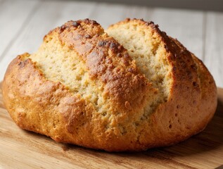 Golden brown rustic loaf of bread on a wooden surface