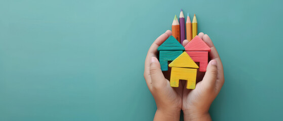 Colorful wooden house shapes held hands with colored pencils top, symbolizing creativity