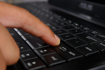 close-up of a finger pressing the ENTER key on a laptop keyboard