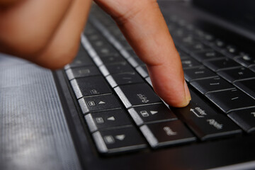 close-up of a finger pressing the ENTER key on a laptop keyboard