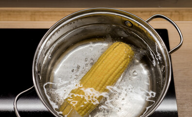 Cobs of sweet corn in a pot of water boiled