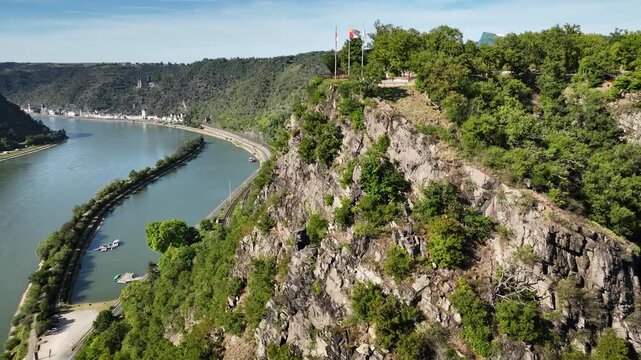Footage of Loreley (Lorelei) cliff and St. Goarshausen with castle Katz in background by Upper Middle Rhine Valley  Shot of sweeping river bend, steep rocky escarpment with viewpoint flags.