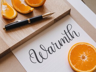 Happiness for a living mindset guide concept. Warmth conveyed through orange slices and elegant handwriting on a wooden surface.