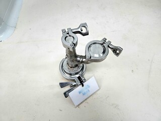 Stainless steel sanitary fitting with clamps and connections.