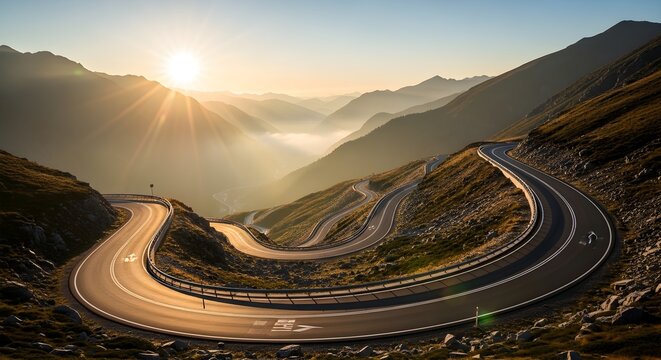 Dramatic winding mountain road illuminated by golden sunrise with sunbeams piercing through misty valleys below