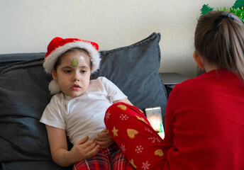 The older sister gives her younger sisters Christmas face painting.