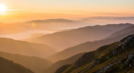Golden sunrise illuminates misty mountain peaks and valleys creating a serene and breathtaking natural landscape vista