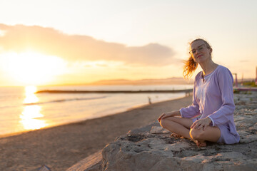 Fototapeta premium Woman relaxing at beach enjoying golden hour sunset