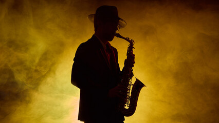 Jazz saxophonist in hat performing with golden stage smoke. Concept of music gear promotion, fashion and lifestyle branding, and editorial visuals for culture magazines.