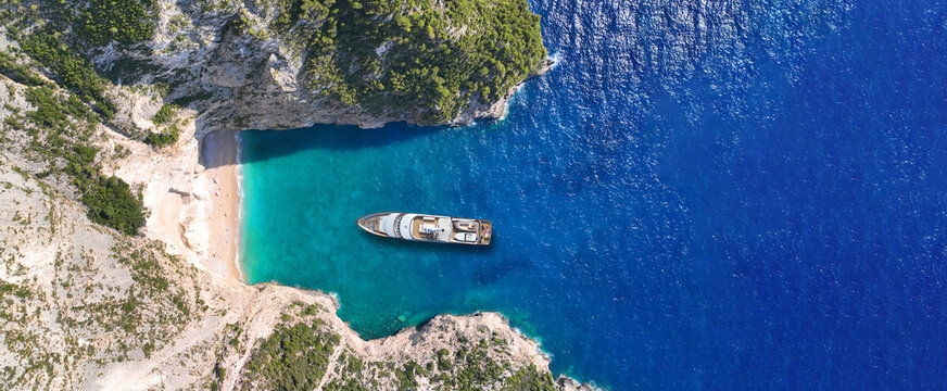 Aerial drone ultra wide panoramic top down photo with copy space of luxury yacht anchored in tropical exotic island with crystal clear turquoise sea