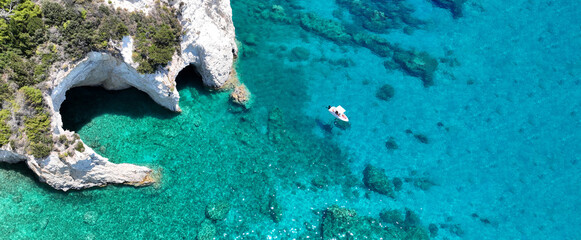 Aerial drone top down ultra wide photo with copy space of inflatable speed boat anchored in tropical exotic rocky island with emerald crystal clear sea © aerial-drone