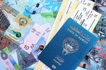 Kuwaiti dinar currency money bills with tickets and passport close up. The concept of travel and...