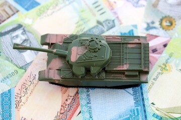 Bahraini dinar currency money bills and toy tank close up. The concept of army funds and weapons...