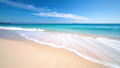 Turquoise ocean waves gently wash onto a pristine sandy beach under a clear blue sky with wispy white clouds creating a serene coastal paradise scene