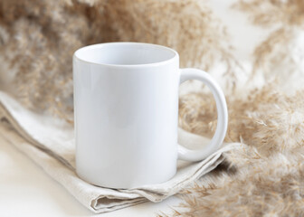 White blank coffee mug on linen near pampas grass Close up, mockup for print on demand